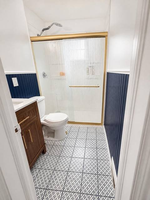 Navy blue bathroom with brushed gold fixtures and ribbed glass shower door