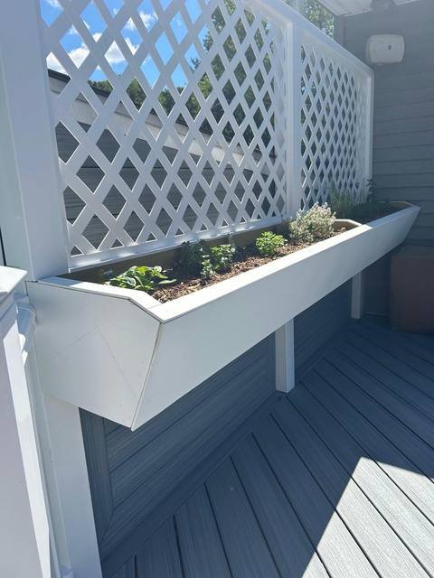 Built-in deck planter box with herbs and white lattice privacy screen