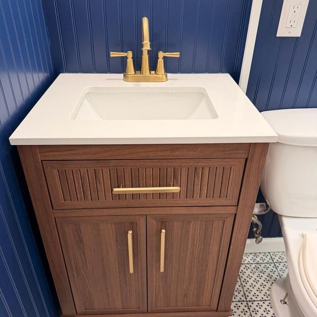 Finished bathroom vanity cabinet with gold hardware